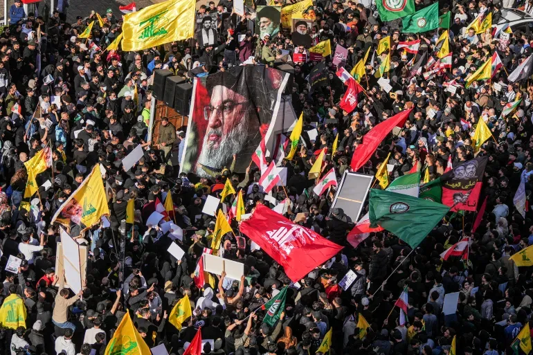 Des manifestants brandissent des drapeaux libanais et du Hezbollah et tiennent des portraits de dirigeants du Hezbollah alors qu'ils se rassemblent lors d'une manifestation contre le Premier ministre libanais Nawaf Salam devant le palais du gouvernement à Beyrouth, au Liban [Hassan Ammar/AP Photo]