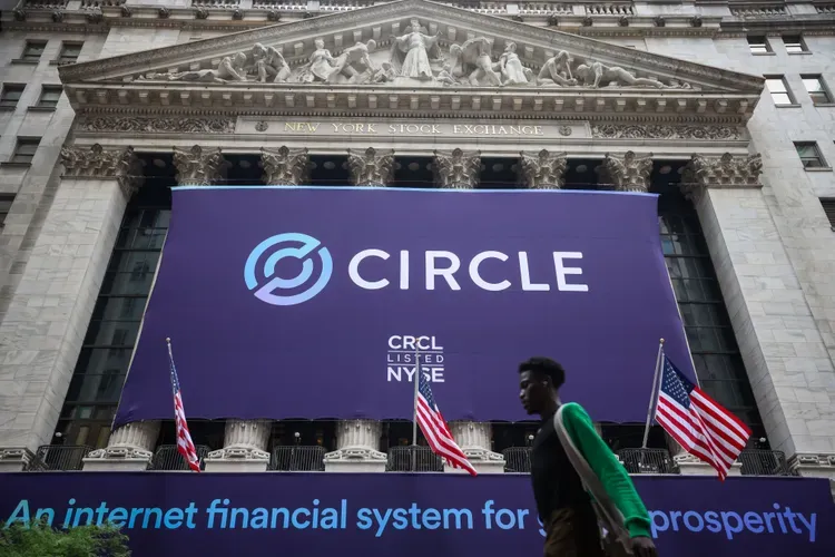 Логотип Circle відображається на Нью-Йоркській фондовій біржі під час лістингу CRCL на фоні прапорів і пішохода